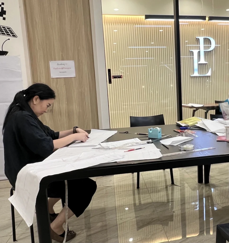 POYA designer reviewing a hand-drafted pattern
